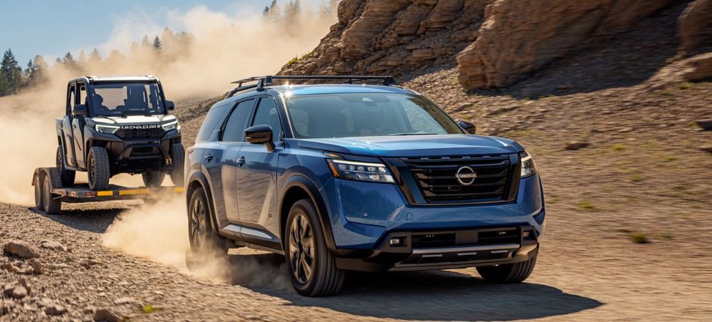 Nissan suv pulling a trailer up a dirt hill Dingmans Collision Repair Nissan-suv-pulling-a-trailer-up-a-dirt-hill-Dingmans-Collision-Repair